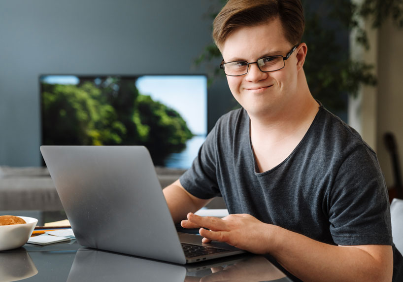 Mann mit Handicap bewirbst sich auf einen Job an seinem Computer.